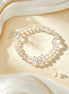 Clear beaded bracelet on a beige fabric background with white flowers